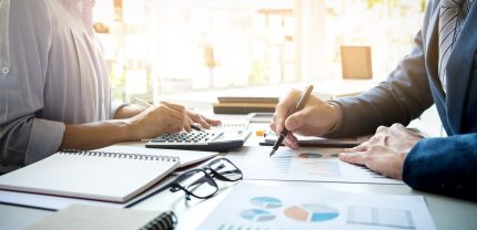 business man financial inspector and secretary making report, calculating or checking balance. Internal Revenue Service inspector checking document. Audit concept